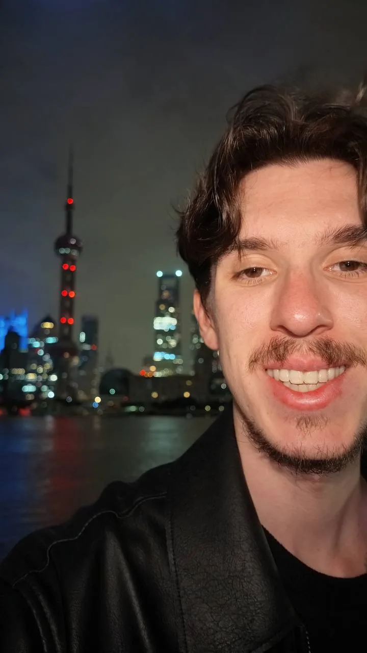 Guillaume à Shanghai, de nuit, devant la skyline du Bund